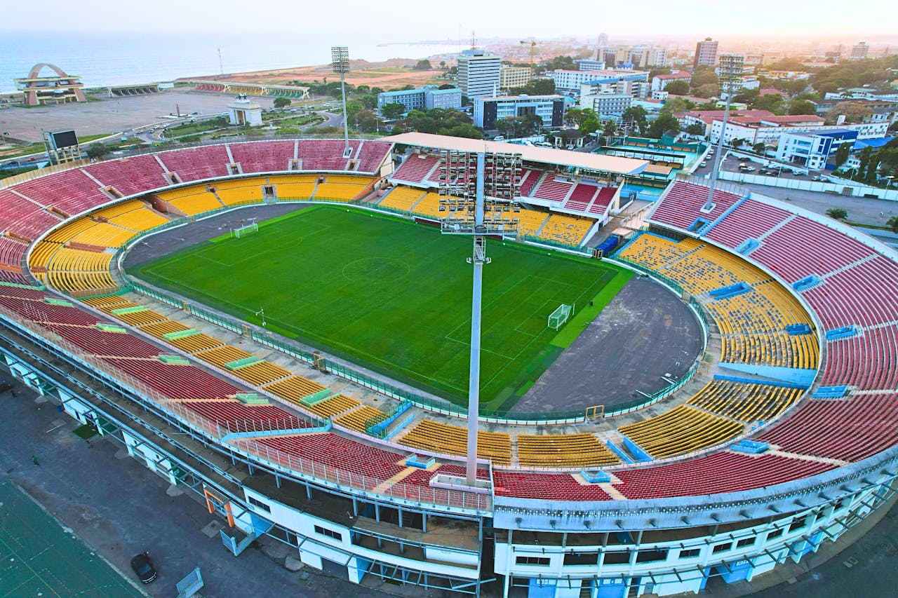 services-img Aerial view of the Accra Sports Stadium, Ghana, at dawn with an empty field.